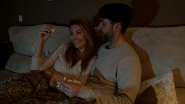 Sevgi dolu bir çift sıcak bir gece geçiriyor, patlamış mısır paylaşıyor ve kanepede birlikte film izliyorlar.