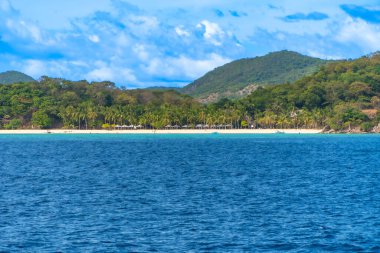 Filipinler 'deki Nido Adası' ndaki Nacpan plajı beyaz kum, palmiye ağaçları ve berrak mavi suyu olan tropik bir cennet sunuyor.
