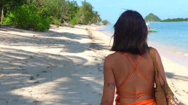 Filipinler 'de el değmemiş beyaz kumsalda çıplak ayakla yürüyen, tropik cennet ve yaz tatili mutluluğu yaşayan, dingin genç bir kadın.