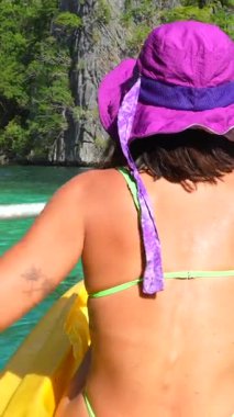 Maceraperest gezgin, turkuaz sularda parlak sarı bir kanoyla kürek çekiyor. Manzaralı El Nido ve Palawan 'ın kireçtaşı uçurumlarını kuşatıyor.