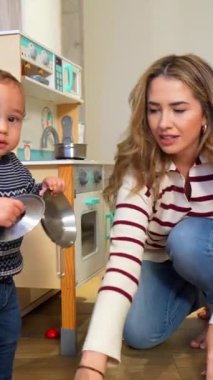 Sevgi dolu bir anne, yaratıcı mutfak oyunlarında oyuncu bir çocuğu meşgul eder, etkileşimli oyuncak etkileşimiyle çocukluk gelişimini destekler.