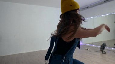 Yetenekli dansçılar, parlak bir stüdyoda, tutkularını ve yeteneklerini sergileyerek dinamik bir gösteri yapıyorlar.