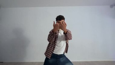 Profesyonel erkek dansçı minimalist kent dans stüdyosunda dinamik çağdaş dans hareketleri uyguluyor, akışkan koreografi yoluyla sanatsal ifadeleri keşfediyor.