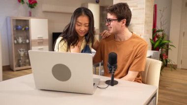 Çok ırklı bir çift birlikte podcast yapıyor, gülüyor ve yaratıcı anları paylaşıyor.