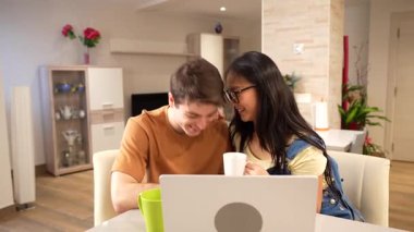 Çok ırklı bir çift evde sessiz bir anın tadını çıkarıyor. Kupalarını yudumlarken laptoplarıyla bağlantı kuruyorlar.