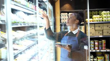 Market işçisi, envanteri yönetmek için bir tablet kullanarak, etkin bir organizasyon ve müşteri memnuniyetini güvence altına alıyor