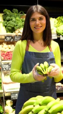 Soğutulmuş raflardan organik bakkaliyeleri dikkatlice seçen, sağlıklı beslenme odaklı mağazalarda sağlıklı besleyici ürünlere göz atan sağlıklı bir kadın.