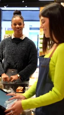 Soğutulmuş raflardan organik bakkaliyeleri dikkatlice seçen, sağlıklı beslenme odaklı mağazalarda sağlıklı besleyici ürünlere göz atan sağlıklı bir kadın.