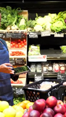 Soğutulmuş raflardan organik bakkaliyeleri dikkatlice seçen, sağlıklı beslenme odaklı mağazalarda sağlıklı besleyici ürünlere göz atan sağlıklı bir kadın.