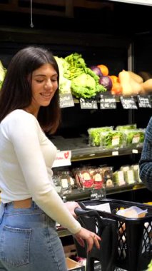 Soğutulmuş raflardan organik bakkaliyeleri dikkatlice seçen, sağlıklı beslenme odaklı mağazalarda sağlıklı besleyici ürünlere göz atan sağlıklı bir kadın.