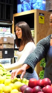 Soğutulmuş raflardan organik bakkaliyeleri dikkatlice seçen, sağlıklı beslenme odaklı mağazalarda sağlıklı besleyici ürünlere göz atan sağlıklı bir kadın.