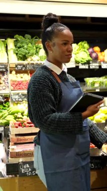 Soğutulmuş raflardan organik bakkaliyeleri dikkatlice seçen, sağlıklı beslenme odaklı mağazalarda sağlıklı besleyici ürünlere göz atan sağlıklı bir kadın.