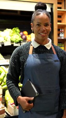 Soğutulmuş raflardan organik bakkaliyeleri dikkatlice seçen, sağlıklı beslenme odaklı mağazalarda sağlıklı besleyici ürünlere göz atan sağlıklı bir kadın.