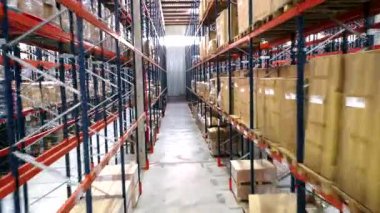 Metal raflara istiflenmiş düzenli mallarla dolu kapsamlı bir lojistik deposu. Sistematik envanter yönetimi ve verimli depolama çözümleri sergiliyor.