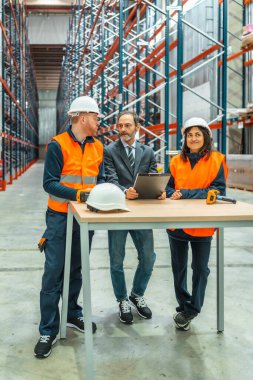 Yönetici, büyük dağıtım merkezindeki depo çalışanlarına lojistik ve envanter yönetimi hakkında bilgi veriyor.