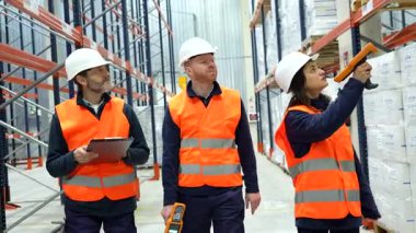 Depo ortamında envanteri yöneten lojistik uzmanları, barkod tarayıcıları kullanan ve depolama rafları ve nakliye bölgelerinde malları takip eden