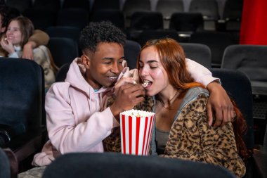 Genç çift sinemada buluşmayı, patlamış mısırları ve karanlık tiyatroda hassas bir anı paylaşmayı seviyor.