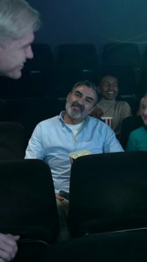 Çeşitli sinema izleyicileri, 3D gözlük takarak, karanlık sinema salonunda patlamış mısırları paylaşarak, sinemaya daldılar.