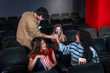 Arkadaşlar patlamış mısır yiyip el sıkışırken canlı bir sinemada heyecanlı bir film izleyip birlikte gülüp eğleniyorlar.
