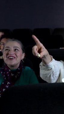 Yaşlı bir çift 3D film izleyip patlamış mısır yiyor, sinemada birlikte vakit geçiriyorlar.