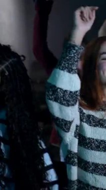 Yüksek enerjiyle dans eden, müziğe yönelen ve coşkulu gece hayatı kutlamalarında kalabalık dans pistinde neşeli anlar paylaşan bir grup genç.