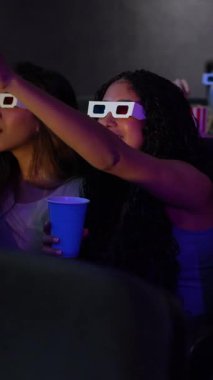 Gençler ve genç yetişkinler 3D gözlük takıyor, patlamış mısır yiyor ve sinemada film seyrediyor, sonra da diskoda dans ediyor.