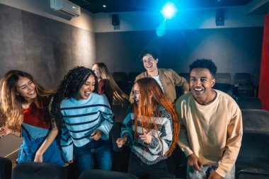 Sinemadaki canlı bir disko etkinliğinde dans eden ve kutlama yapan çok ırklı arkadaşlarınız her anın tadını çıkarıyorlar.