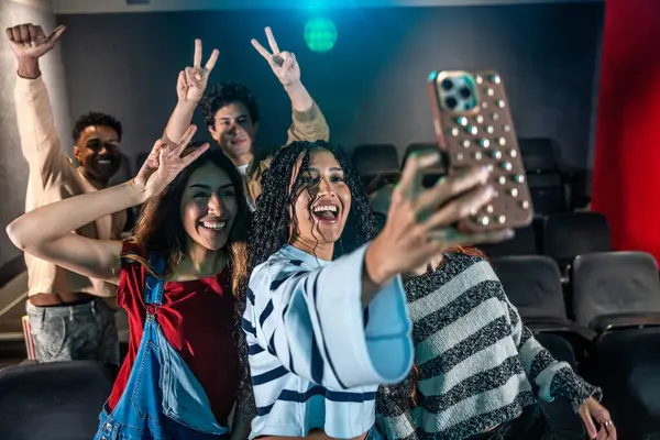 Gençler bir disko dansı sırasında sinemada selfie çekiyorlar, eğleniyorlar ve anın tadını çıkarıyorlar.