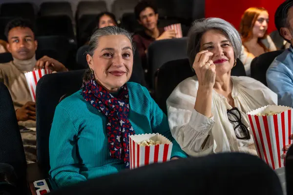 İki son sınıf öğrencisi kadın patlamış mısır yer ve sinemada film izler, boş zamanlarının keyfini çıkarırlar.