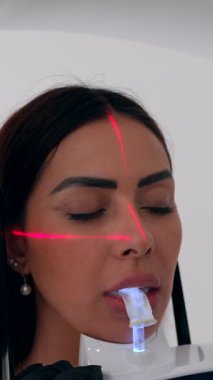 Profesyonel dişçi, kapsamlı sözlü sağlık muayenesi sırasında yenilikçi tıbbi görüntüleme teknolojisi kullanan kadın hasta üzerinde 3D diş tarama prosedürü uyguluyor.