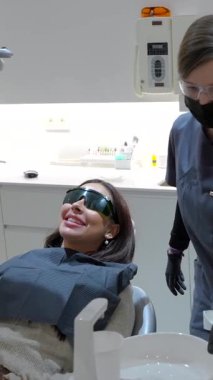 Diş beyazlatma işlemi için gelişmiş lazer teknolojisi kullanan profesyonel dişçi, modern klinik ortamlarda hastanın gülüşünü hassas diş bakımıyla değiştiriyor.