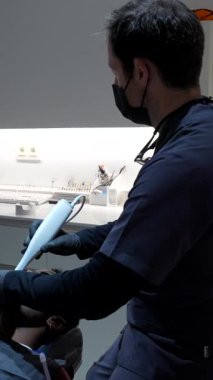 Dişçi, modern diş kliniğindeki hastalar üzerinde diş taraması yaparak dijital diş modelini yaratıyor.