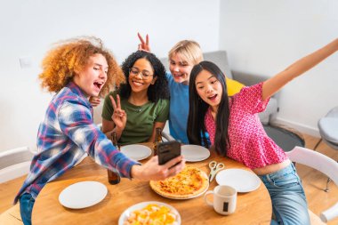 Dört farklı arkadaş, sıradan bir buluşmada pizza, aperatif ve içki içerken bir selfie ile eğlenceli bir anı yakalar.