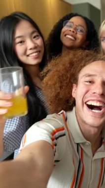 Çok kültürlü arkadaşlar şakacı anlar paylaşıyorlar, abartılı ifadeler takınıyorlar, aynı zamanda ev mutfağında spontane selfie çekiyorlar.