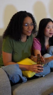 Milenyumlar film gecesi heyecanını paylaşıyor, coşkulu tepkilerle şüpheli filmlere bağlanıyor, oturma odasındaki kanepede gülüyor ve tezahürat yapıyorlar.