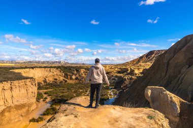 Uçurumun kenarında dikilen turist, Navarre, İspanya 'daki gerçekten de çölün büyüleyici manzarasına hayran kaldı.
