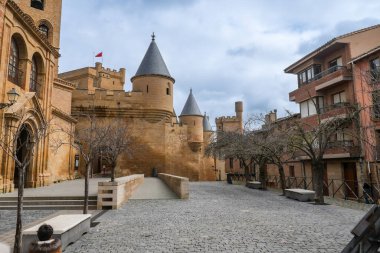 Olite 'nin görkemli kraliyet sarayı Navarre, İspanya, gösterişli ortaçağ mimarisi ve kaldırım taşı caddelerindeki tarihi olite kasabasının siluetine hükmediyor.