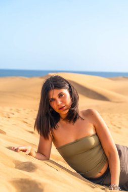 Genç bir kadın kumulların kumullarında yatıyor, büyük kanarya, kanarya adaları, İspanya, yaz tatilinin tadını çıkarıyor.