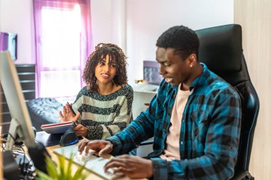 İki genç profesyonel, bir erkek ve bir kadın, bir bilgisayar projesinde birlikte çalışıyorlar. Bir ofis ortamında, fikirleri ve stratejileri tartışıyorlar.