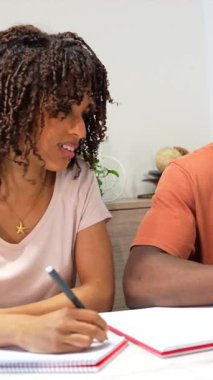 Genç öğrenciler çalışırken, çalışırken, not yazarken ve rahat çalışma ortamında dizüstü bilgisayarla çalışırken, odaklanmış kararlılıkla akademik projeye dahil olurken,