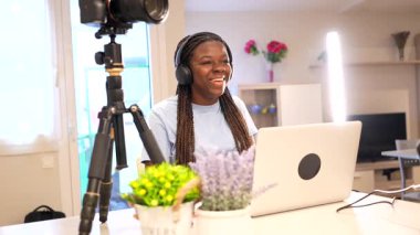 İki genç kız çevrimiçi içeriği bir araya getirerek, bir ev stüdyosunda podcast kaydediyor.