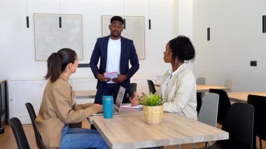 Proje tartışmasına katılan, fikirleri paylaşan ve çağdaş bir ofis ortamında strateji üzerinde işbirliği yapan iş arkadaşları