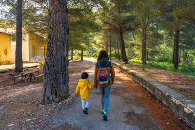 Anne ve oğlu, Gandesa, Tarragona 'daki yazı tipi tapınağının doğal ortamında huzurlu bir yürüyüş yapıyorlar.