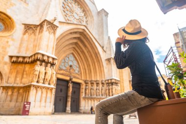 Hasır şapkasını tutan turist güneşli bir günde tarhuna katedralinin görkemine hayran kaldı.