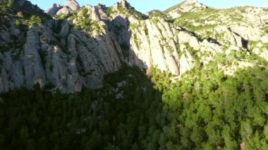 Engebeli uçurumları süpüren güneş ışığı ve Montserrat dağ sırasındaki yeşil ağaçlar katalonya manzarasındaki dramatik jeolojik oluşumları gözler önüne seriyor.