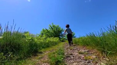 Errenteria, gipuzkoa, Bask ülkesinde güneşli bir günde Aldura Dağı 'nda yürüyüş yapan genç bir çocuk.