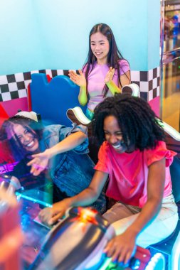 Çoklu etnik arkadaşlar eğlenceli bir hafta sonu geçiriyorlar, atari oyunları oynuyorlar, gülüyorlar ve birlikte geçirdikleri mutlu anları kutluyorlar.