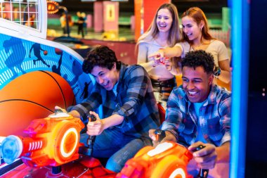 Genç yetişkinler birlikte eğlenirken neşeli bir bowling salonunda, kahkaha ve heyecanla oyun oynuyorlar.