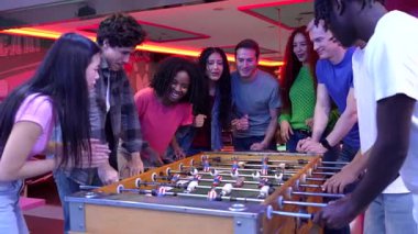 Genç yetişkinler bowling salonunda eğlenceli langırt müsabakalarına katılıyor, gece eğlencesi sırasında arkadaşlarıyla tezahürat yapıyor ve paylaşılan heyecanı yaşıyorlar.