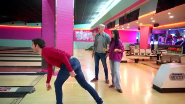 Bir grup arkadaş birlikte bovling oynuyorlar, sırayla bowling oynuyorlar ve eğleniyorlar.